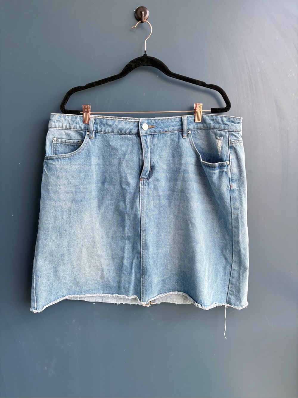 Dex light-wash distressed denim mini skirt with a raw, frayed hem.